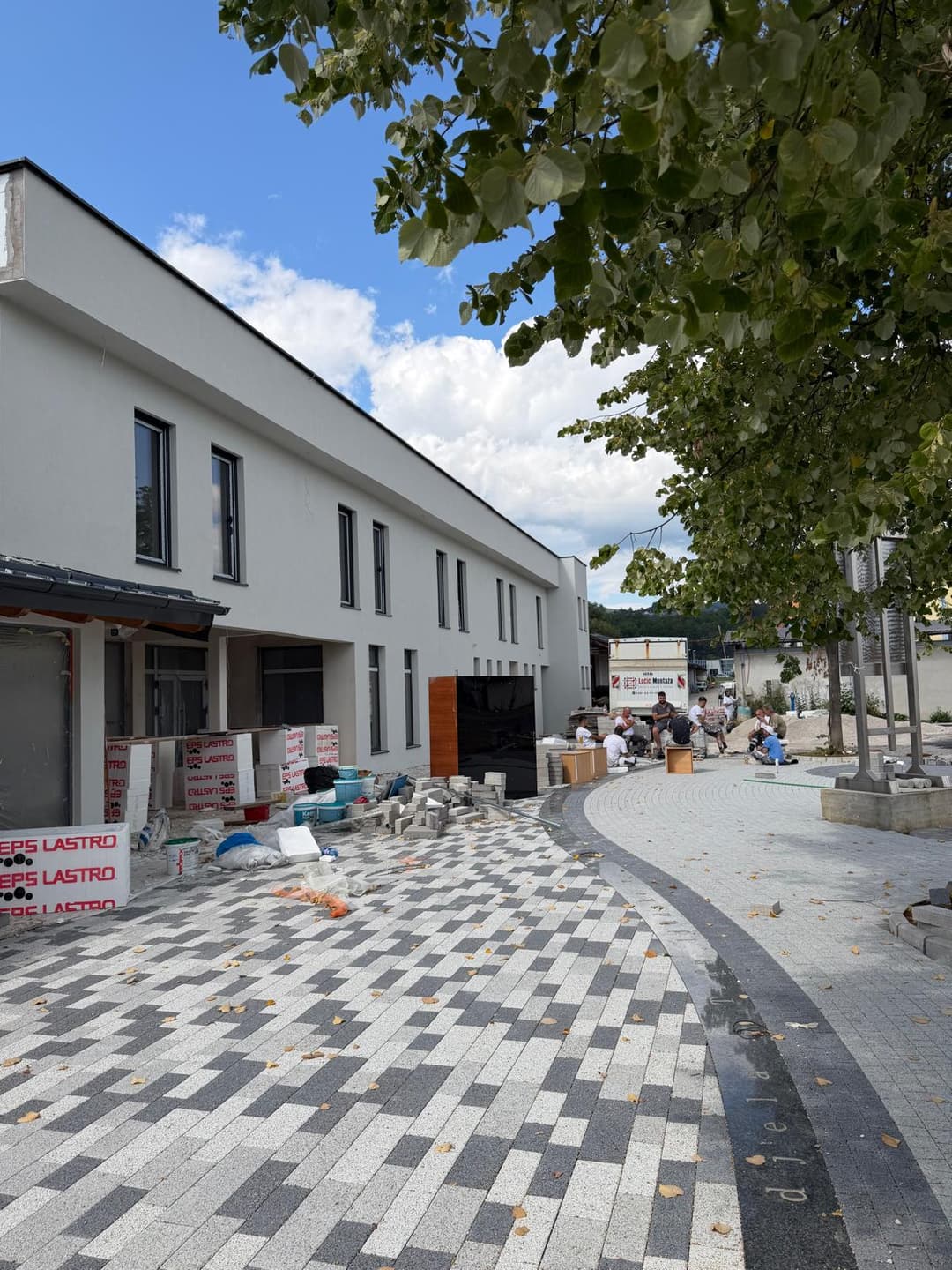 Dovršena bijela fasada objekta s popločanim prilazom
